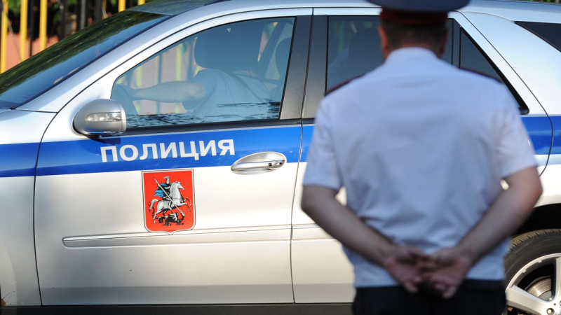 Полицейский автомобиль и сотрудник полиции